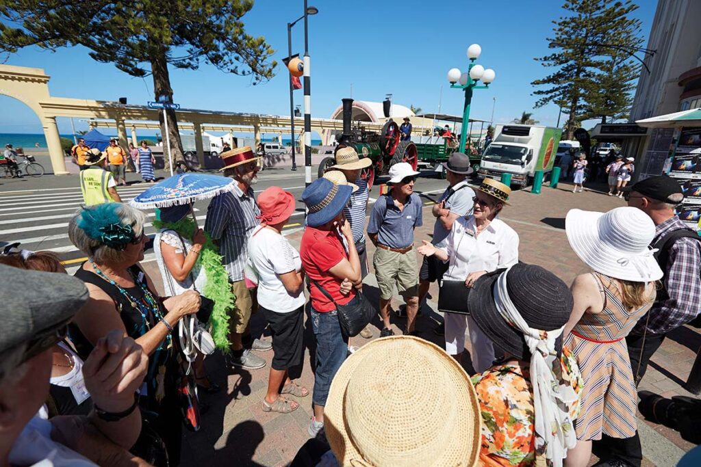 A group of tourists is led by a woman with a microphone outside